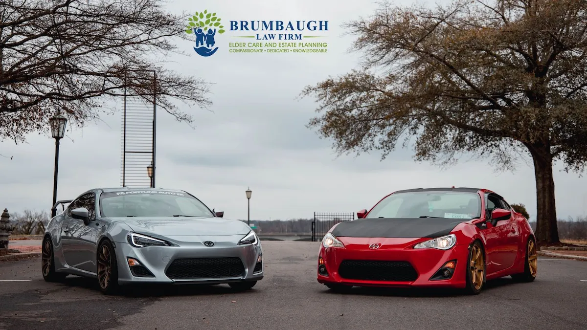 Two sports cars parked by waterfront under cloudy sky